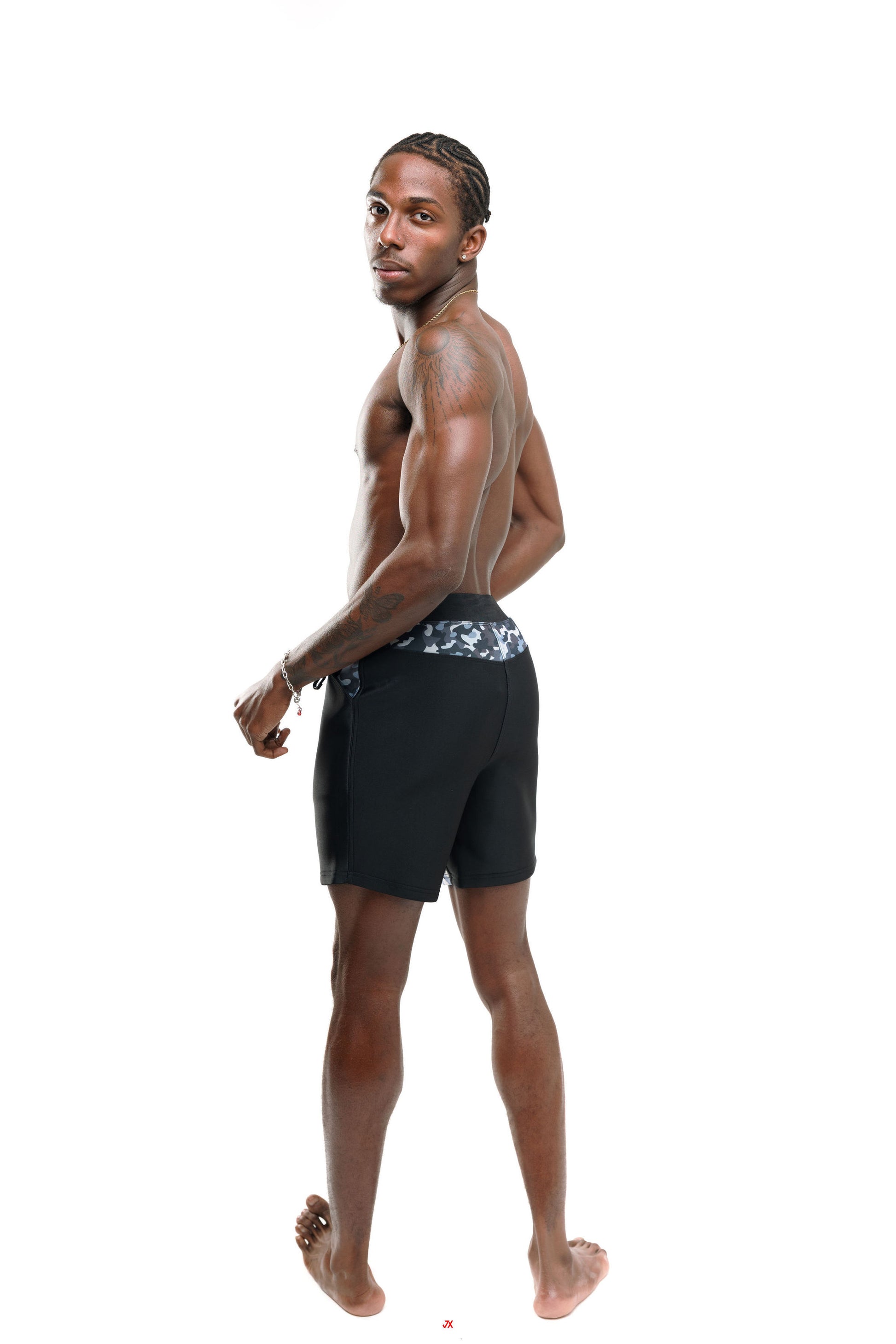 Man wearing black and grey camo 4" swim shorts with a patterned waistband back profile on a white background