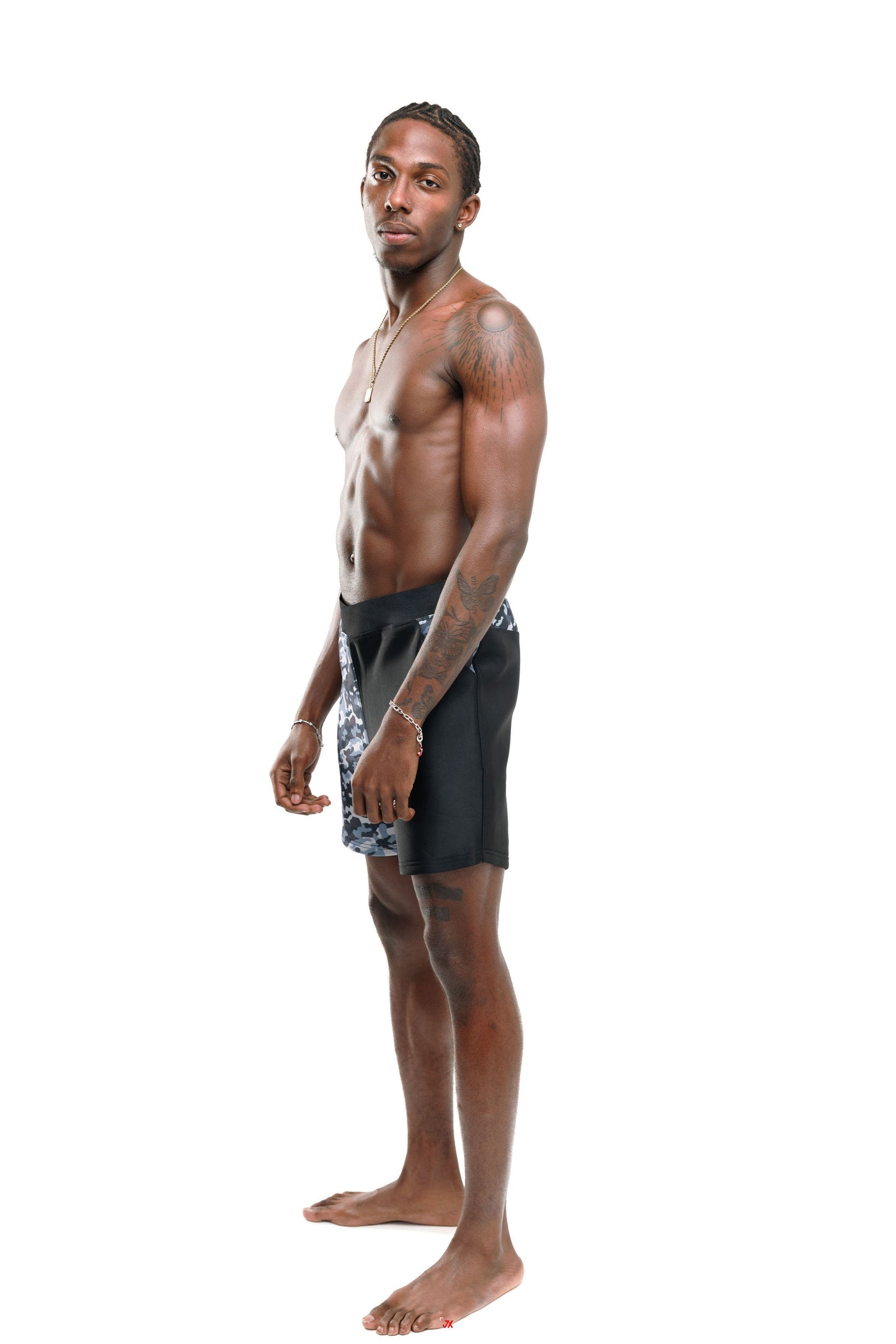 Man wearing black and grey camo 6" swim shorts side profile (black) on a white background