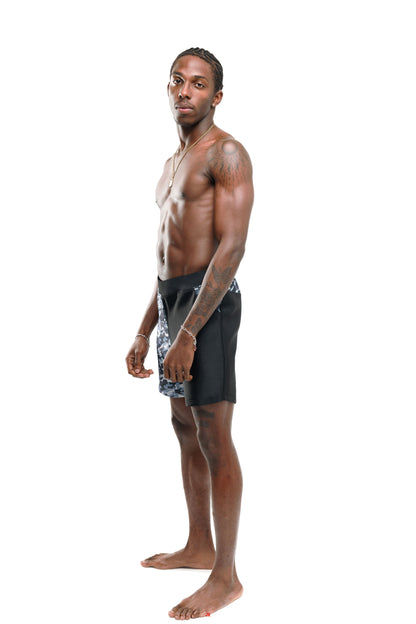 Man wearing black and grey camo 6" swim shorts side profile (black) on a white background