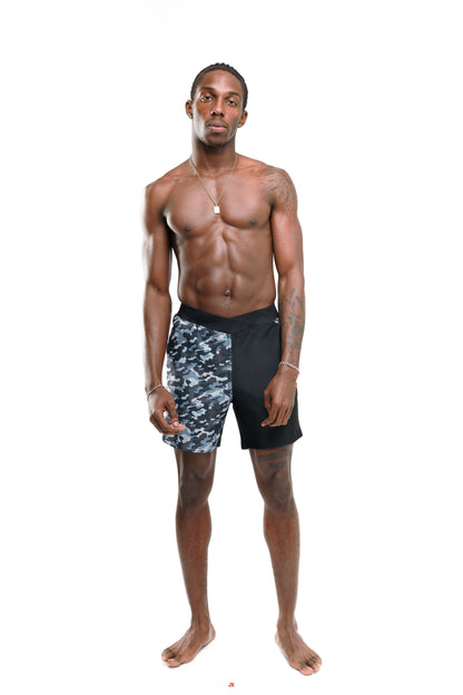 Man wearing black and grey camouflage 6" swim shorts on a white background