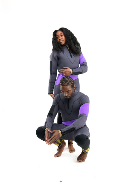 Two people wearing matching gray and purple scuba suit editorial pose on a white background