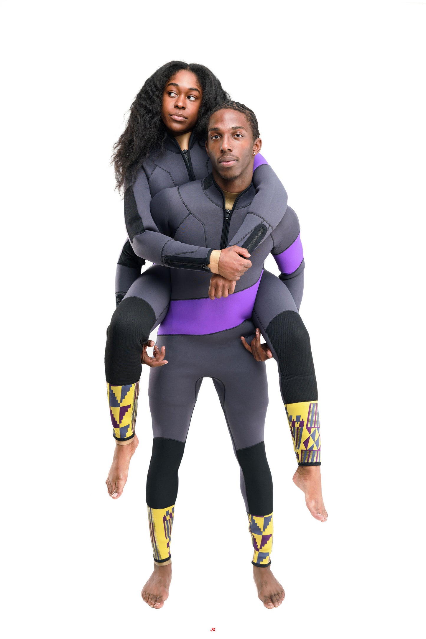 Two people wearing matching superhero-themed wetsuit gazing in different directions on a white background